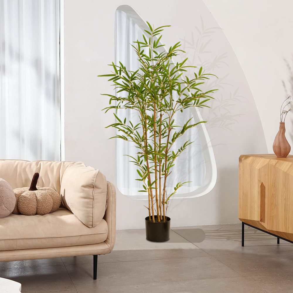 A Natural Guest artificial bamboo plant beside a living-room sofa